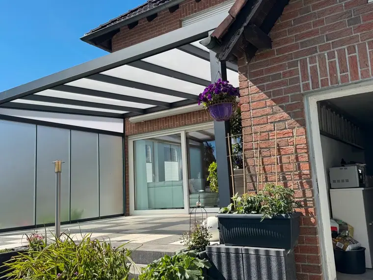 Glas-Schiebewand unter einer Terrassenüberdachung an einer Klinkerfassade
