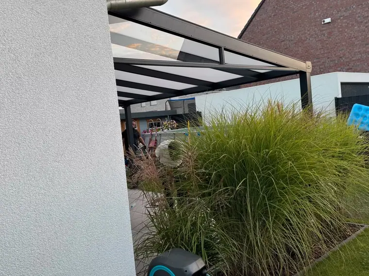 Detail der Dachkante einer Terrassenüberdachung mit Ziergräsern im Vordergrund