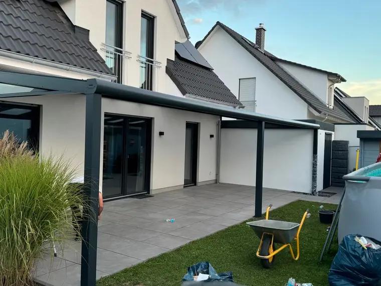 Lange Terrassenüberdachung an einem modernen weissen Wohnhaus