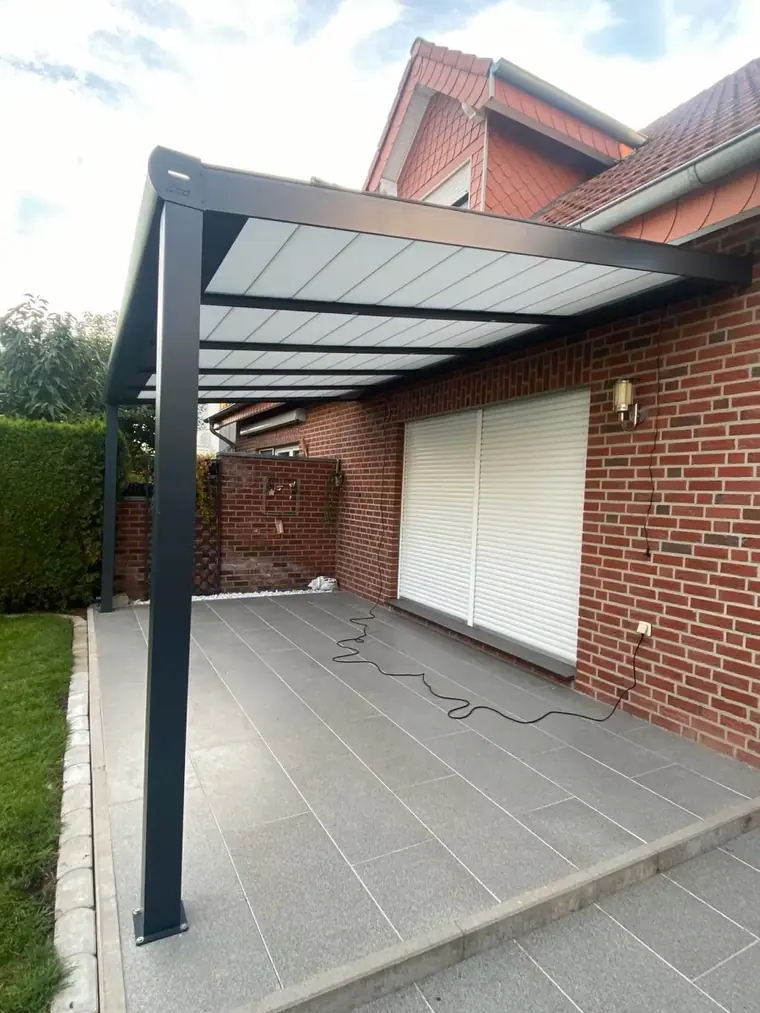 Blick unter eine Terrassenüberdachung an einem roten Klinkerhaus